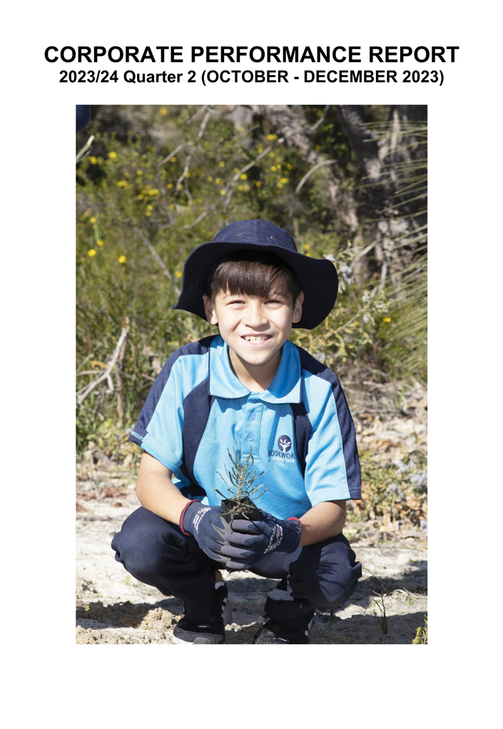A child kneeling in the dirt holding a small plant

Description automatically generated