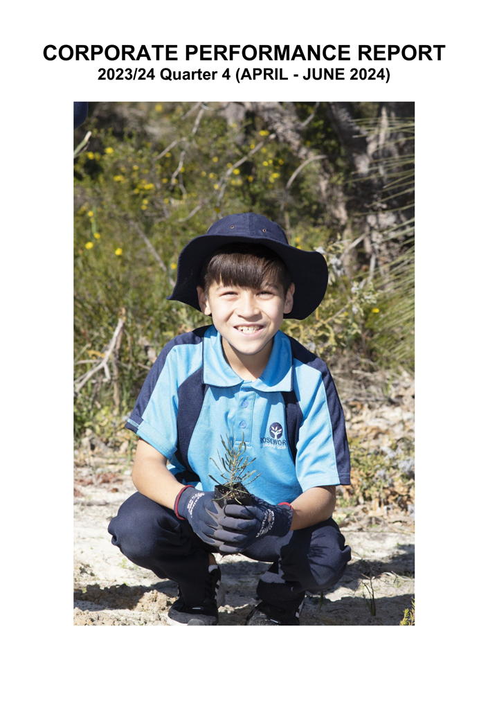 A child kneeling in the dirt holding a small plant

Description automatically generated